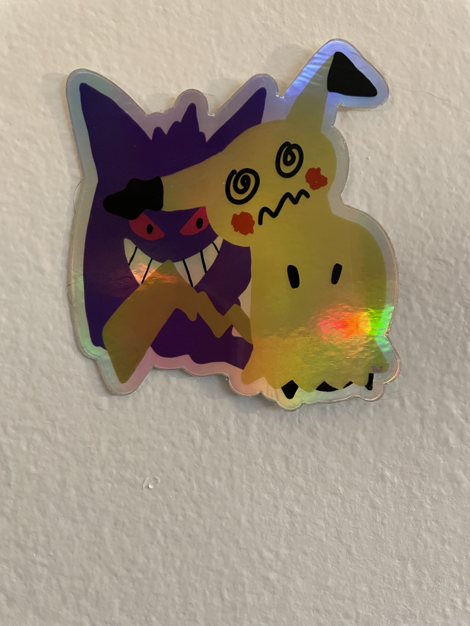 Image of a sticker of the Pokemon mimikyu, with the Pokemon gengar hiding in its shadow..