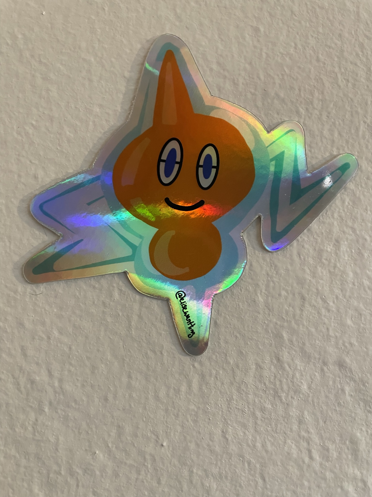 Image of a sticker of an electric Pokemon, rotom, who is blue and orange.